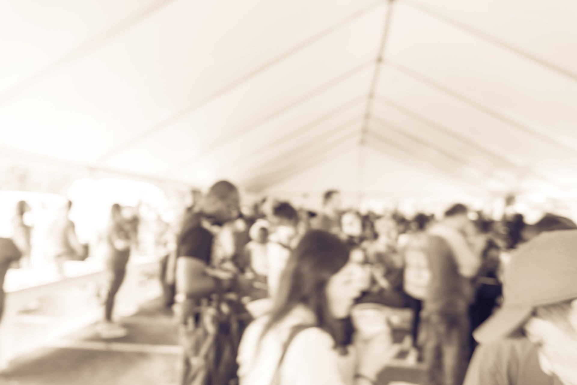 Blurred image crowd of multiethnic people in tent at an community event/tradeshow in Houston, Texas, USA. Defocused background of indoor community fair. Vintage tone.